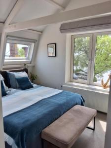 恩克赫伊曾Appartement Havenzicht的一间卧室设有蓝色的床和2个窗户。
