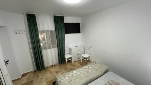 曼加利亚Vila Theo的一间卧室配有一张床、两把椅子和一个梳妆台