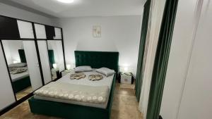 曼加利亚Vila Theo的一间卧室配有一张带绿椅的床