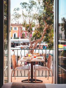 格里莫Le Suffren Hôtel的树上阳台的桌椅