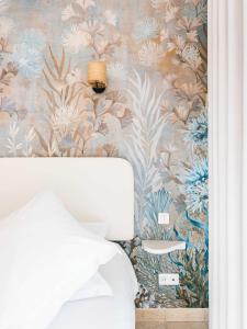 格里莫Le Suffren Hôtel的卧室配有花卉壁画和1张床