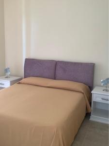 卡帕乔-帕埃斯图姆Caputaquis的卧室内一张带紫色床头板的床