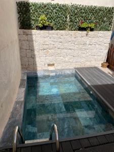 ChellaCasa Rural Sarsalet的砖墙旁的一个带木甲板的游泳池