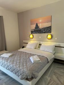 艾西奥斯索蒂斯Akrogiali Hotel的卧室配有一张大床,墙上挂有绘画作品