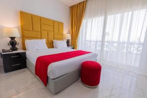 阿莱曼premium sea porto marina suite的一间卧室配有一张带红色毯子的大床