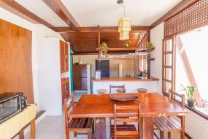 阿拉亚尔达茹达Cavalo Marinho Flats的厨房以及带木桌和椅子的用餐室。