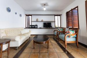 帕纳米林Casa Cajueiro - Praia de Pirangi por Carpediem的客厅配有沙发、椅子和桌子