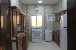 麦地那شقة خاصة للعائلات فقط的厨房配有炉灶和冰箱,设有窗户。