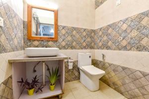 MājraFabHotel KK Residency的浴室设有卫生间、镜子和水槽