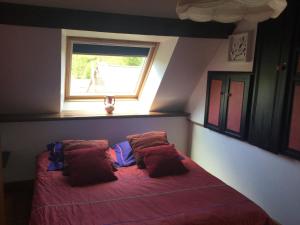 圣詹姆斯Le cottage normand的一间卧室配有一张带红色床单的床和一扇窗户。