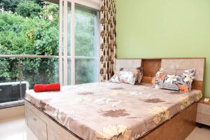 波戈马洛Ranghavi sands Apartment with Pool - near beach and Dabolim Airport的一张大床,位于带大窗户的房间里