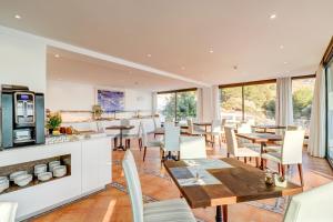 卡拉圣维森特霍坡萨尼乌酒店的厨房以及带桌椅的用餐室。