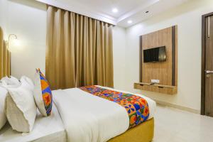 新德里FabHotel Vishesh Villas的酒店客房,配有床和电视