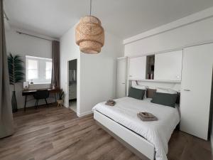 桑斯Le Laurencin Sens - Le Parisien的白色卧室配有床和书桌