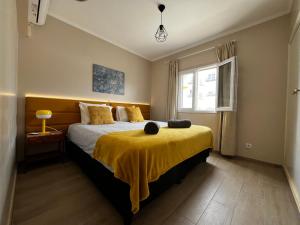 阿尔布费拉Vista Mar e Terra的一间卧室配有一张黄色毯子床