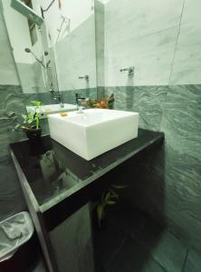 埃拉Kai Kazee Ella的浴室设有白色水槽和镜子