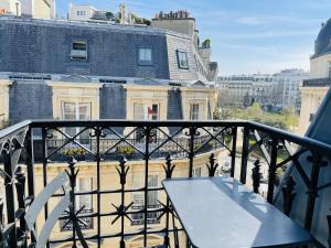 巴黎Chalgrin Boutique Hotel的阳台的桌子,享有建筑的景色