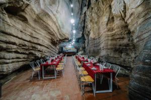 吉婆岛Victor Charlie Hostel的洞穴中的一间用餐室,配有桌椅