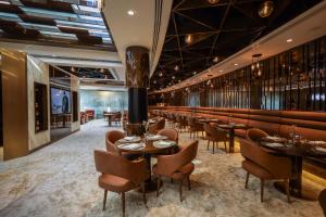 迪拜Golden Sands Boutique Hotel-Dubai Creek的一间带桌椅的餐厅和一间酒吧