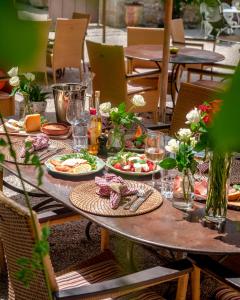 塔拉斯孔普罗旺斯马斯迪斯康帝思酒店的一张木桌,上面放着食物盘