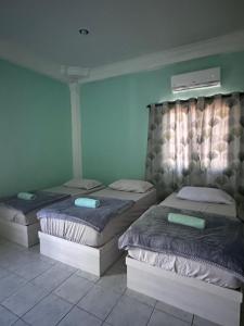 SipitangSipitang Hometown B&B的绿墙客房内的两张床