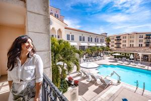 迈阿密科勒尔盖布尔斯凯悦酒店，​​迈阿密的站在酒店带游泳池的阳台上的女人