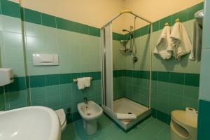 兰佩杜萨Hotel Baia Turchese的绿色瓷砖浴室设有水槽和淋浴