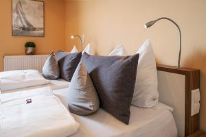 哈格瑙Boutiquehotel zur Winzerstube - Adults Only的一间卧室配有两张床、枕头和灯
