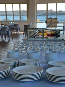 兰佩杜萨Hotel Baia Turchese的自助餐,包括白板和玻璃杯在桌子上