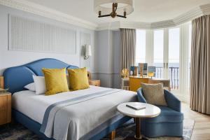 布莱顿霍夫布莱顿格兰德酒店的一间卧室配有蓝色的床和蓝色椅子
