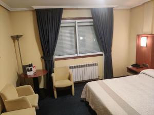 圣地亚哥－德孔波斯特拉Motel Punta Cana的酒店客房设有一张床、两把椅子和一扇窗户。