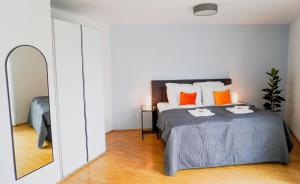 汉诺威At home in the inner city的一间卧室配有带橙色枕头和镜子的床