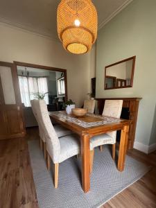 利物浦Liverpool Victorian Townhouse - 3 Bedrooms的一间带木桌和椅子的用餐室