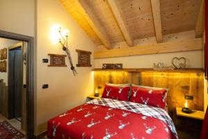 利维尼奥Chalet Da Florin的一间卧室设有红色的床和木制天花板。