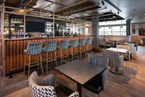 克劳利ibis Styles London Gatwick Airport的一间带桌椅的餐厅和一间酒吧