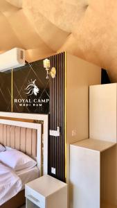 瓦迪拉姆ROYAl WADI RUM CAMP的一间卧室,配有一张床,墙上有标志