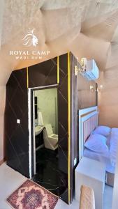 瓦迪拉姆ROYAl WADI RUM CAMP的小房间设有床和镜子