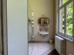 赫纲兰德B&B Le Manoir de la Douve的一间带水槽和镜子的浴室以及窗户。