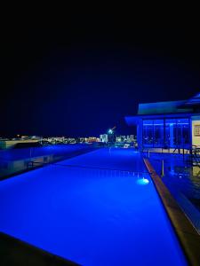 哥打京那巴鲁Riverside Opulent Nights at Sky Hotel的一个晚上的游泳池,以城市为背景