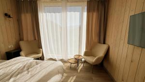 丰达塔Sycamore Retreat Fundata的一间卧室配有两把椅子、一张床和窗户