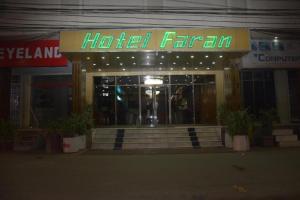 卡拉奇Faran Hotel的酒店客房前面有一个 ⁇ 虹灯标志