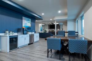 欧文Soka Suites Dallas - Las Colinas的厨房以及带桌椅的用餐室。