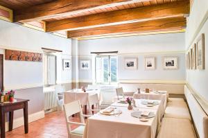 SellanoCastello Di Postignano Relais的一间设有白色桌椅的用餐室