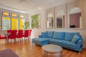 阿亚蒙特Casa Verde Ayamonte的客厅配有蓝色的沙发、桌子和椅子
