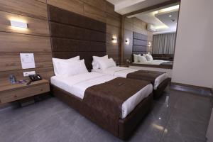 朱尼耶Ibiza Hotel的配有木墙的酒店客房内的两张床