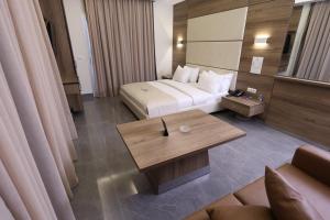 朱尼耶Ibiza Hotel的酒店客房配有一张床铺和一张桌子。