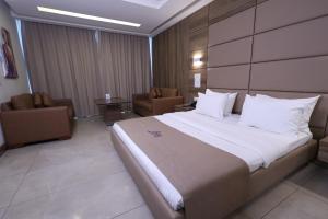 朱尼耶Ibiza Hotel的酒店客房带一张大床和椅子