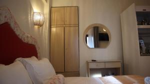 萨尔蒂维克酒店的一间卧室配有一张床、梳妆台和镜子