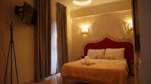 萨尔蒂维克酒店的一间卧室配有一张带红色床头板的床和窗户