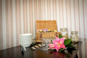 林顿西奈之家酒店的一张桌子上放着篮子和一朵粉红色的花